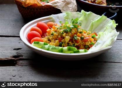Vietnam food, fried rice, make from rice, egg, sausage, dried shrimp, bean, cucumber, tomato, carrot and scallion, close up of dish on wooden background