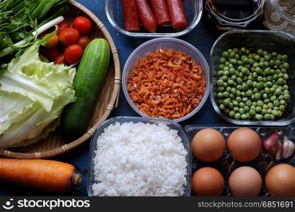 Vietnam food, fried rice, make from rice, egg, sausage, dried shrimp, bean, cucumber, tomato, carrot and scallion, processing with colorful food material on wooden background