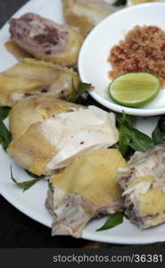 Vietnamese food, boiled chicken plate with pepper and salt, serve with laksa leaves and lemon