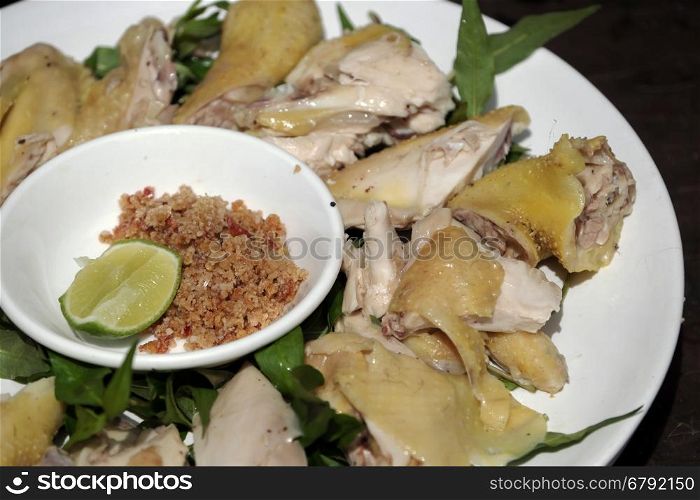 Vietnamese food, boiled chicken plate with pepper and salt, serve with laksa leaves and lemon