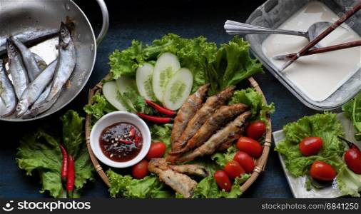 Vietnamese food for family meal at lunch or dinner, fried fish with tamarind sauce and green vegetable, delicious food homemade on wooden background
