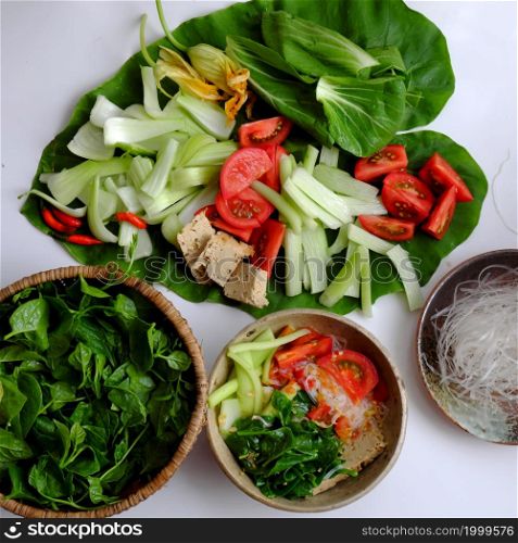 Vietnamese green vegetables hot pot for dinner weekend, tomato, bok choy, tofu skin, colocasia gigantea with noodles, delicious and healthy eating that rich fiber, vitamin for vegetarian