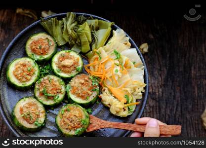 Vietnamese homemade vegetarian eating on black plate on wooden background, grilled vegetables with slice of winter melon stuff with tofu and carrot, delicious vegan meal that frugal, healthy.