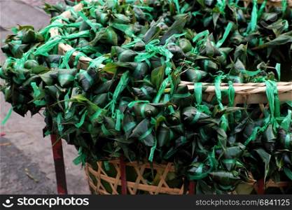 Vietnamese traditional food for may 5th, is double five festival or tet doan ngo, group of sticky rice cake in green leaf, also call banh u tro with pyramidal shape at open air market