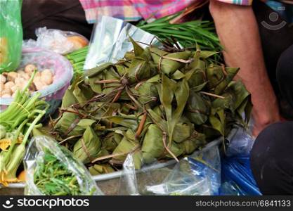 Vietnamese traditional food for may 5th, is double five festival or tet doan ngo, group of sticky rice cake in green leaf, also call banh u tro with pyramidal shape at open air market