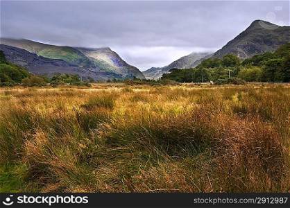 View along Llanberis Pass towards Glyder Fawr on left and Snowdon on right on cloudy overcast day