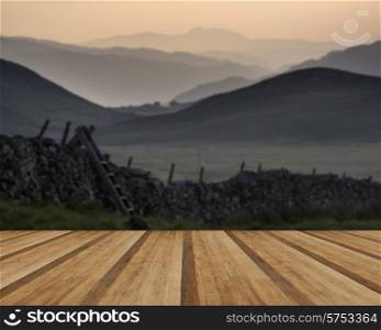 View along misty valley towards Snowdonia mountains. View along countryside fields towards misty Snowdonia mountain range in distance with wooden planks floor