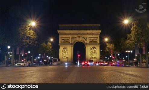 View along the Champs Elysees of the Arc de Triomphe, Paris illuminated at night with vehicular traffic on the street