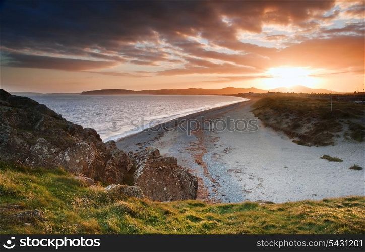 View along West coast of Wales towards beautiful sunset with sunbeams and stunning clouds formations