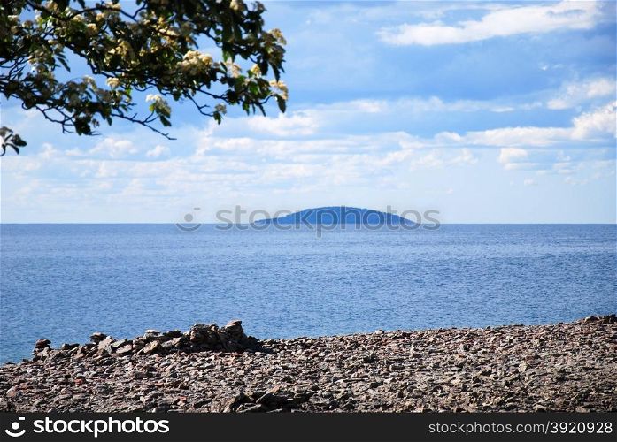 View at a blue island in the horizon from the swedish island oland in the Baltic Sea
