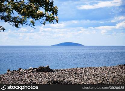 View at a blue island in the horizon from the swedish island oland in the Baltic Sea