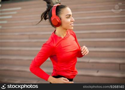 View at active young beautiful woman running in urban enviroment