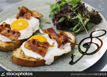 View at bacon and fried eggs on toast with  lettuce decoction
