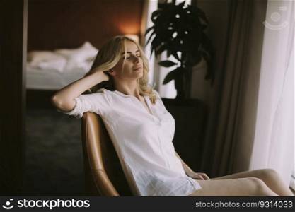 View at blond woman sitting by window at day light