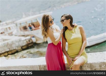 View at female friends having fun on the sea shore on sunny day