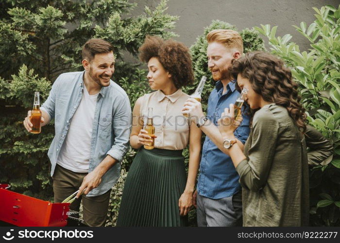 View at happy friends grilling food and enjoying barbecue party outdoors