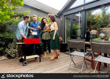 View at happy friends grilling food and enjoying barbecue party outdoors