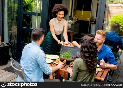 View at happy friends grilling food and enjoying barbecue party outdoors