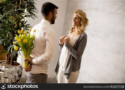 View at man giving bouquet of yellow tulips to his girlfriend