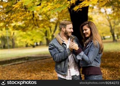 View at smiling couple hugging in autumn park and having fun