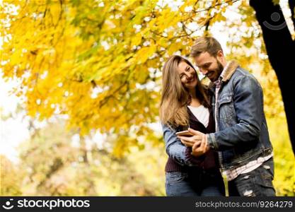 View at smiling couple hugging in autumn park and having fun