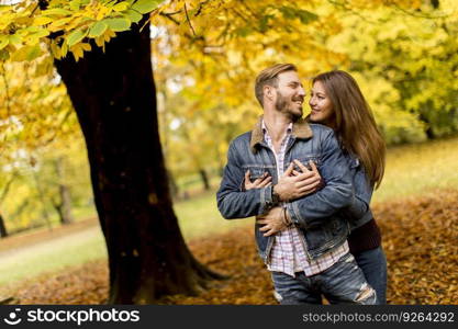 View at smiling couple hugging in autumn park and having fun