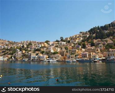 View at Symi town with multiple colorful houses, Greece.