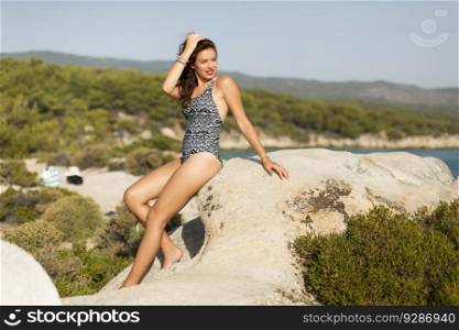 View at woman on rock over the sea in summer