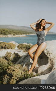 View at woman on rock over the sea in summer