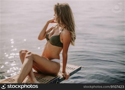 View at young attractive woman sitting on  luxury yacht floating at sea