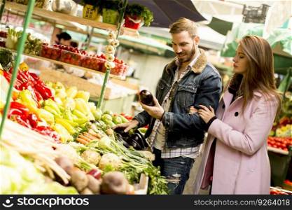 View at young couple buying vegetables on a market