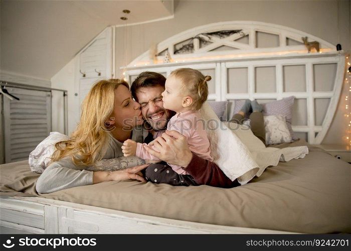 View at young family having fun on bed in bedroom