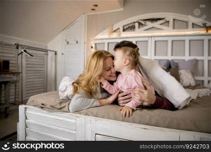 View at young family having fun on bed in bedroom