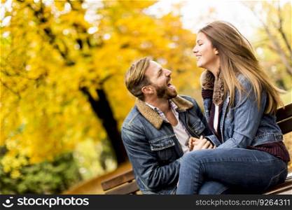 View at young loving couple on a bench in autumn park