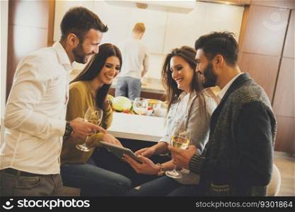 View at young people with white wine in the kitchen