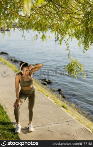 View at young woman with headphones  taking a break during exercising outside