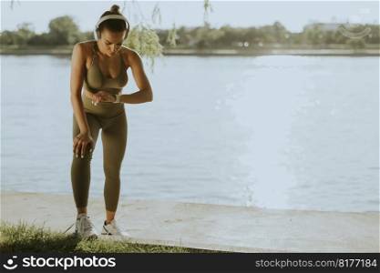 View at young woman with headphones  taking a break during exercising outside
