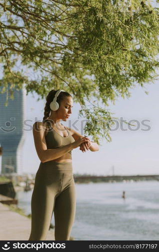 View at young woman with headphones  taking a break during exercising outside