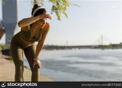 View at young woman with headphones  taking a break during exercising outside