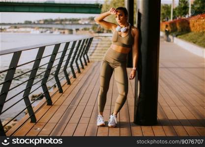 View at young woman with headphones  taking a break during outdoor exercising