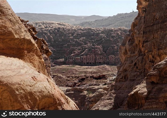 View between rocks from a distance to the centre of the Necropolis of Petra, Jordan, middle east