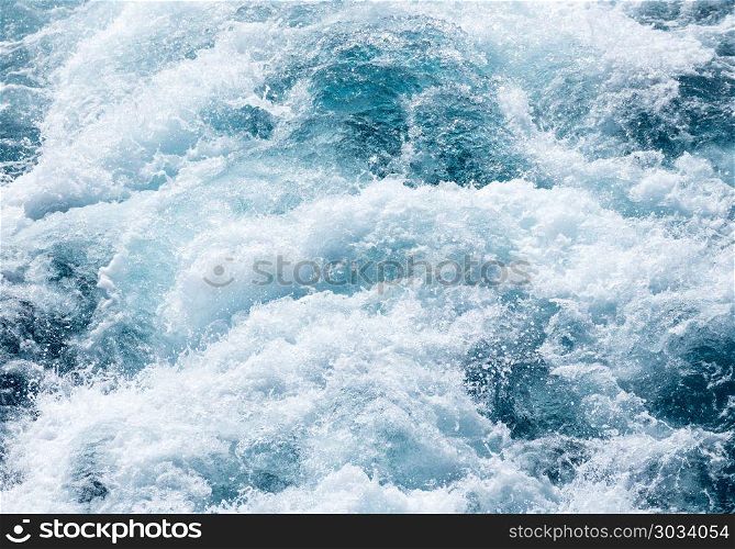 View down at the aft of cruise ship with churning ocean. View down at the powerful churning ocean behind a cruise ship at sea. View down at the aft of cruise ship with churning ocean