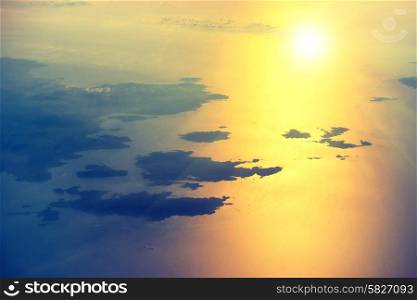 View from a plane to sunset on the sky. Fluffy clouds background