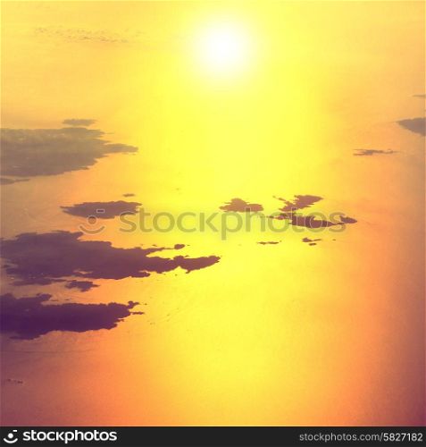 View from a plane to sunset on the sky. Fluffy clouds background