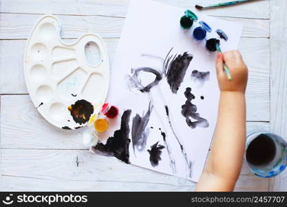 view from above. child draws a brush and paints top view. Flat lay art tools for painting.. view from above. child draws a brush and paints top view. Flat lay art tools for painting.Artwork workplace