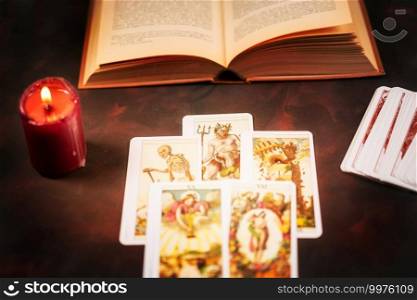 View from above of tarot cards with candlelight and book on the darkness background,Halloween and future reading concept.