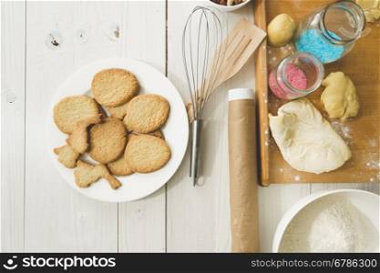 View from above on cooked cookies on dish and kitchen utensils on table