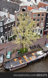 View from above on historic houses and houseboat on a canal in Amsterdam, Netherlands.