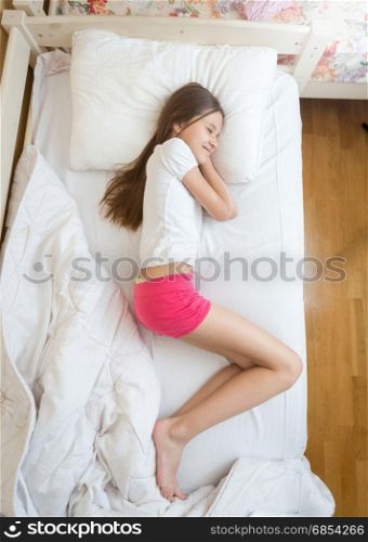 View from above on teenage girls in pink pajamas sleeping on bed