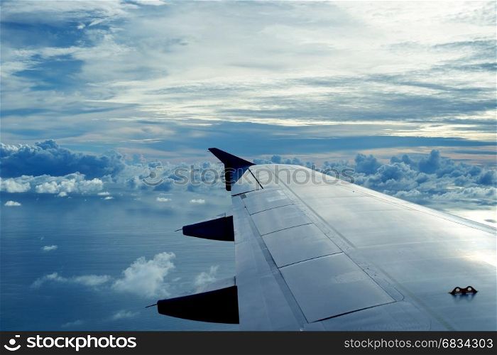view from aircraft wing flying over beautiful clouds